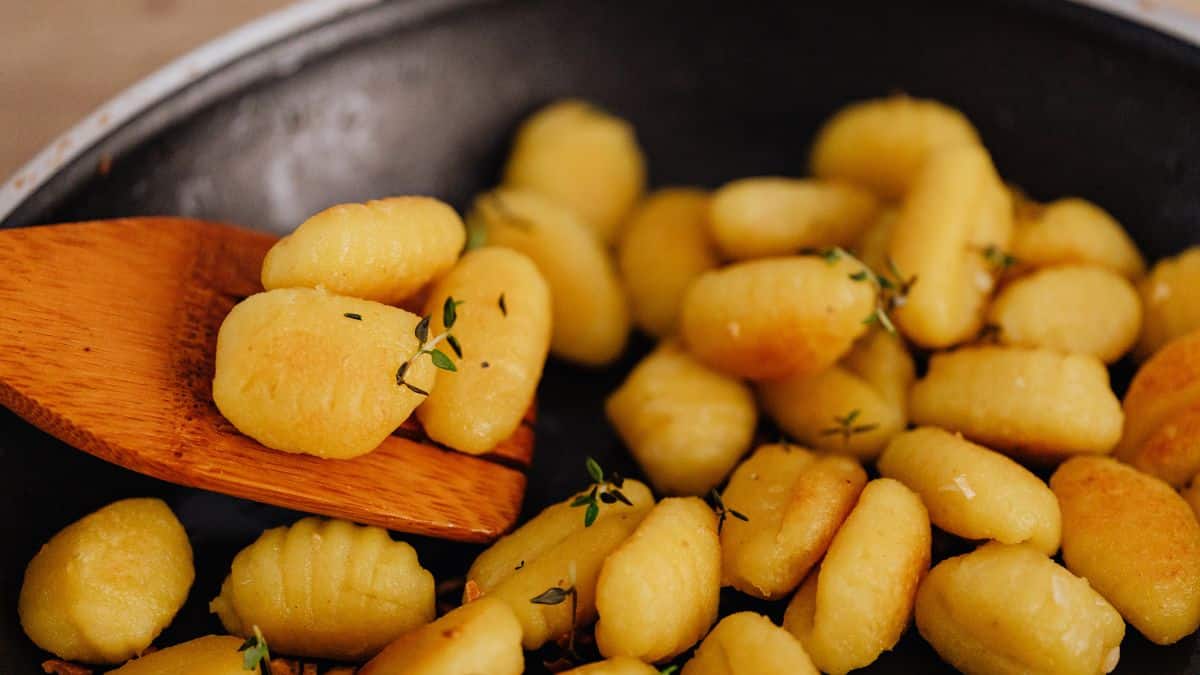 Batatas douradas preparadas com pouco óleo em frigideira, ilustrando consumo mais saudável do alimento